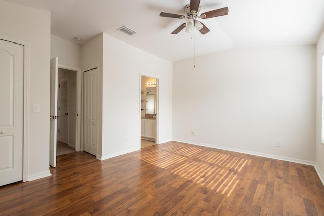 unfurnished bedroom featuring ceiling fan, vaulted ceiling, dark wood-type flooring, and ensuite bath