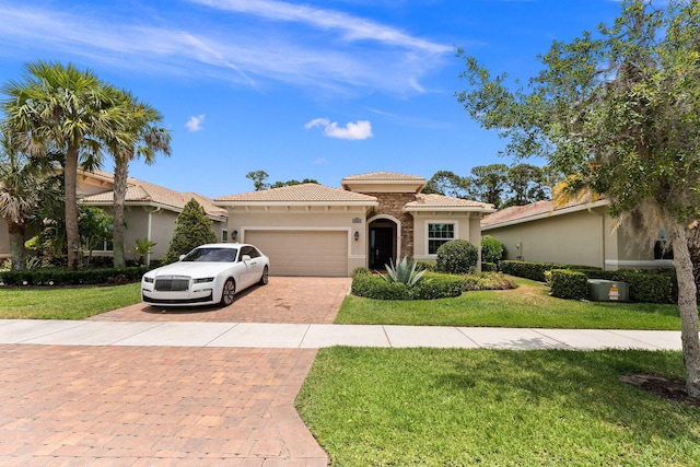 mediterranean / spanish-style house with a garage and a front lawn