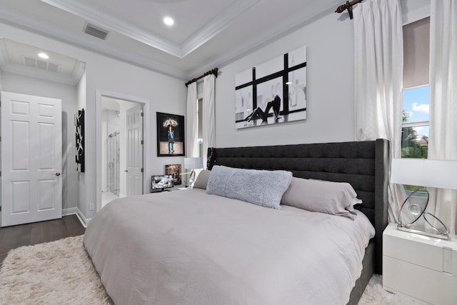 bedroom featuring hardwood / wood-style flooring, crown molding, and a tray ceiling