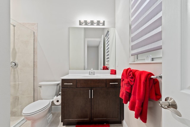 bathroom featuring toilet, vanity, and a tile shower