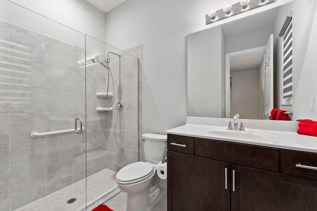 bathroom featuring a shower with shower door, toilet, and vanity