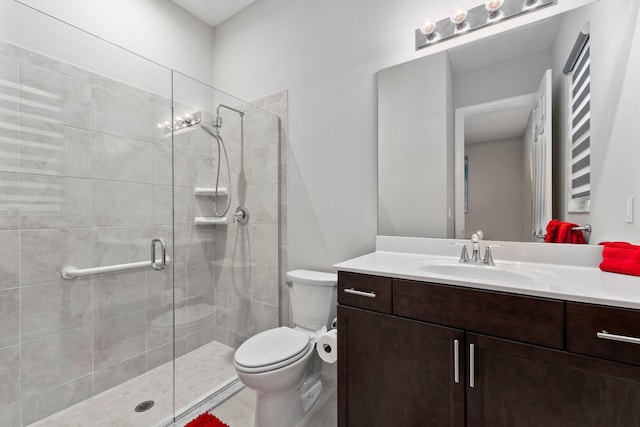 bathroom featuring vanity, a shower with shower door, and toilet