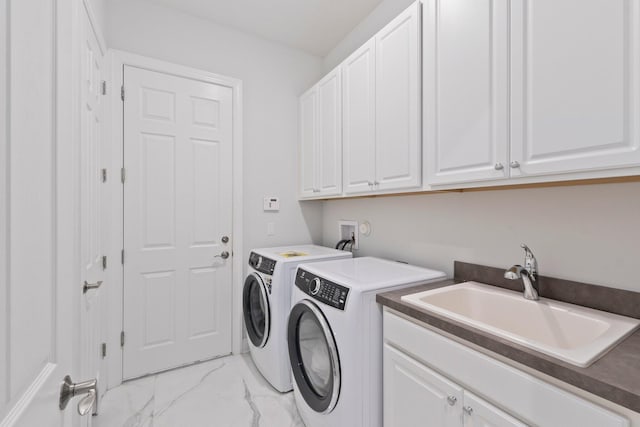 clothes washing area featuring washing machine and clothes dryer, sink, cabinets, and light tile patterned floors