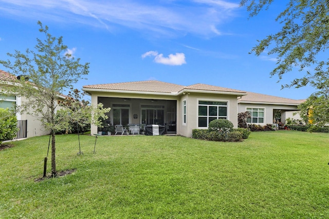 back of property featuring a yard and a sunroom