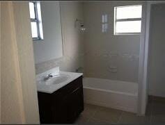 bathroom with vanity and shower / washtub combination