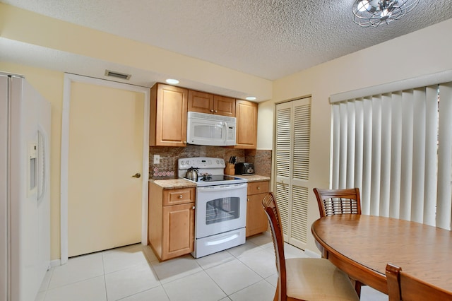 kitchen with tasteful backsplash, white appliances, light tile patterned floors, and a textured ceiling