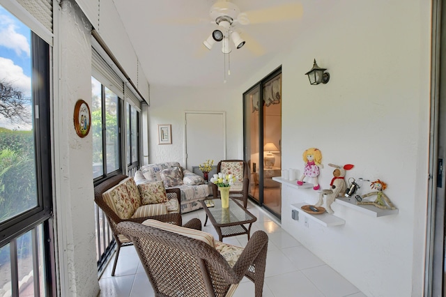 sunroom with tile patterned flooring, a ceiling fan, and an outdoor hangout area