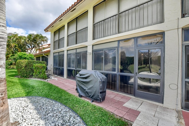 rear view of house with a tile roof and a patio area