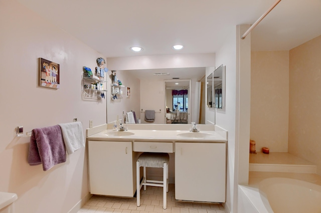 bathroom featuring tile patterned flooring, double vanity, a washtub, and a sink
