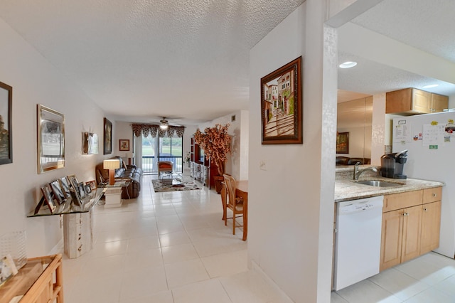 corridor featuring a sink, a textured ceiling, and light tile patterned floors