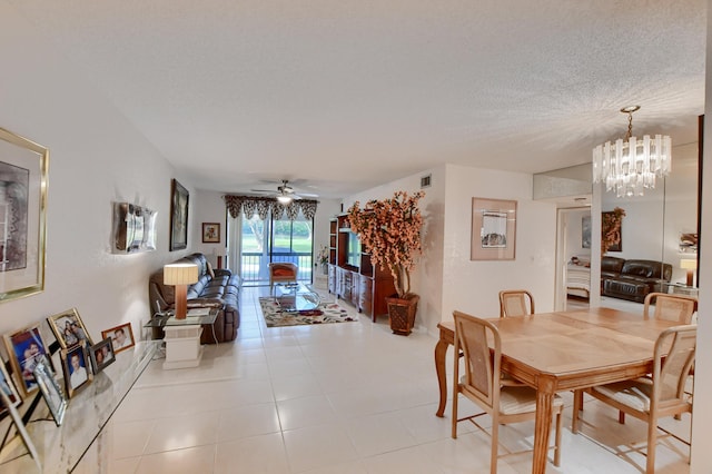 dining area featuring a textured ceiling, visible vents, and ceiling fan with notable chandelier