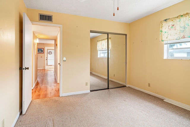 unfurnished bedroom with carpet flooring, a closet, and a textured ceiling