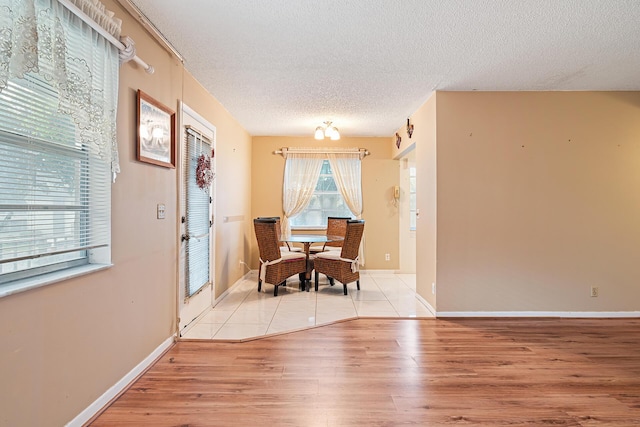 dining space with light hardwood / wood-style floors and a textured ceiling