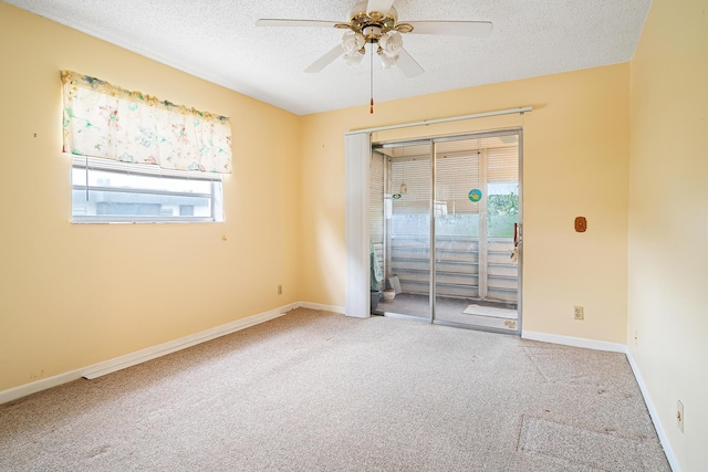 carpeted spare room with ceiling fan and a textured ceiling