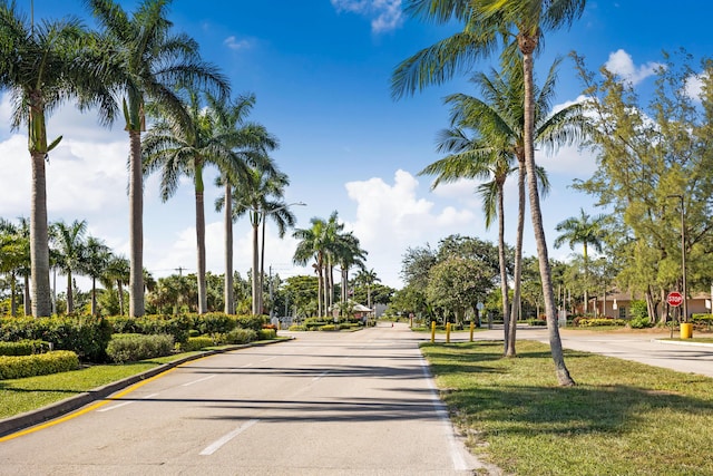 view of road featuring street lights, traffic signs, and curbs