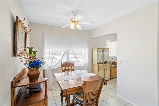 tiled dining room featuring a textured ceiling and ceiling fan