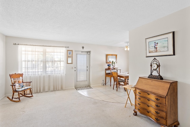 entrance foyer with light carpet, a textured ceiling, and ceiling fan