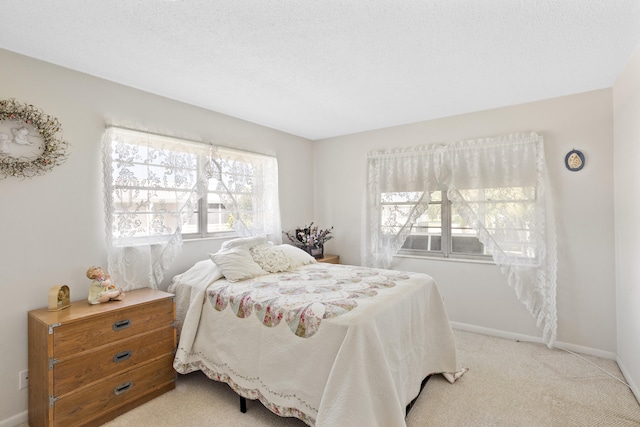 bedroom featuring a textured ceiling and light carpet