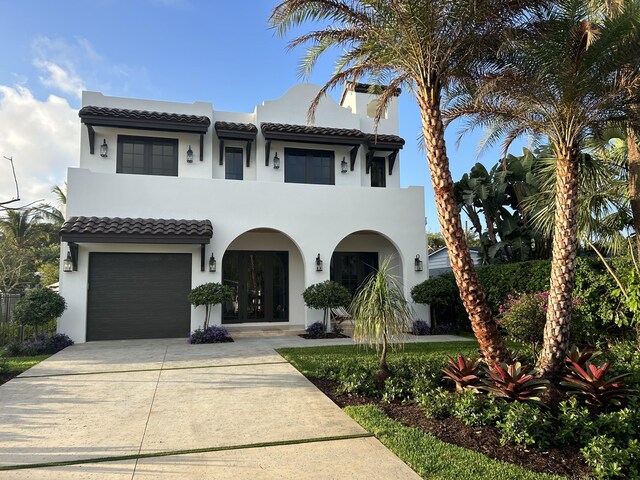 mediterranean / spanish-style home with a front yard and a garage