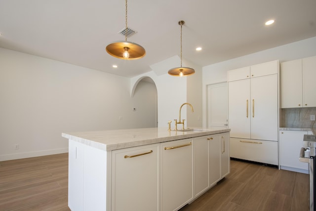 kitchen with sink, pendant lighting, white cabinets, and a kitchen island with sink