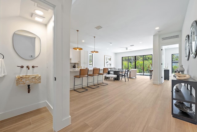 226 NE 11th St, Delray Beach, FL 33444 - kitchen with electric stove, custom range hood, a sink, light wood-style floors, and white cabinets