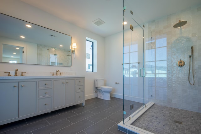 bathroom featuring toilet, a shower with door, vanity, and tile patterned flooring