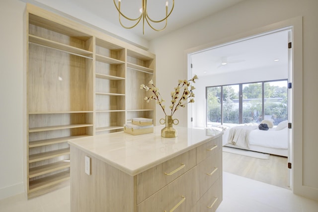 spacious closet featuring a notable chandelier