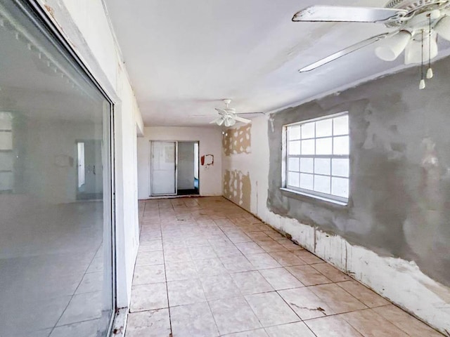 empty room with ceiling fan and light tile patterned floors