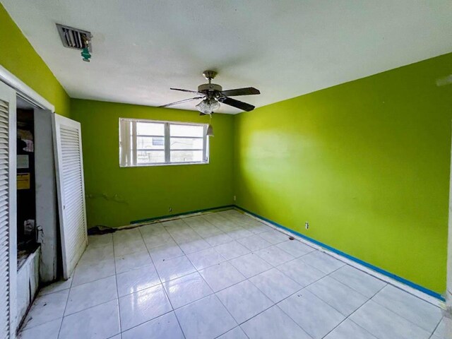 spare room featuring light tile patterned flooring and ceiling fan