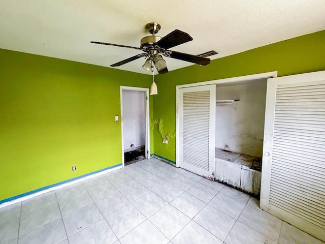 unfurnished bedroom with baseboards, visible vents, ceiling fan, a textured ceiling, and a closet