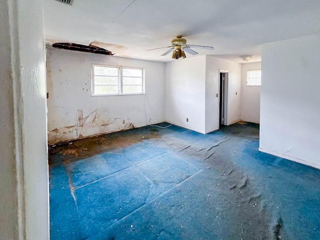 empty room featuring ceiling fan and a wealth of natural light