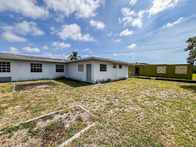 rear view of house featuring a patio and a lawn