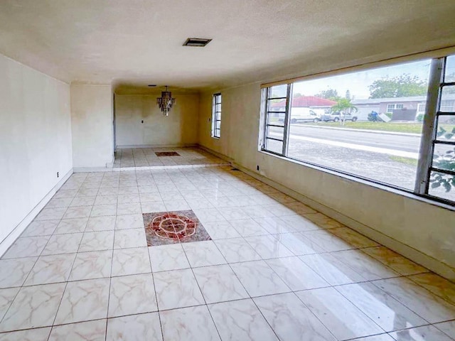 spare room featuring visible vents and baseboards