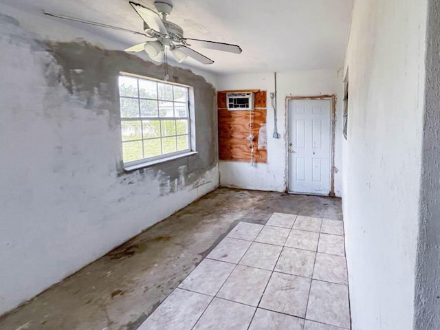 foyer with concrete floors, a wall unit AC, and ceiling fan