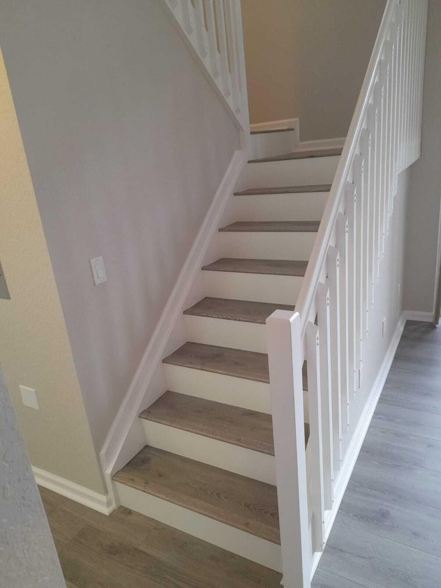 staircase with hardwood / wood-style floors