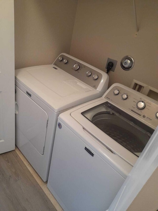 washroom with washer and clothes dryer and wood-type flooring