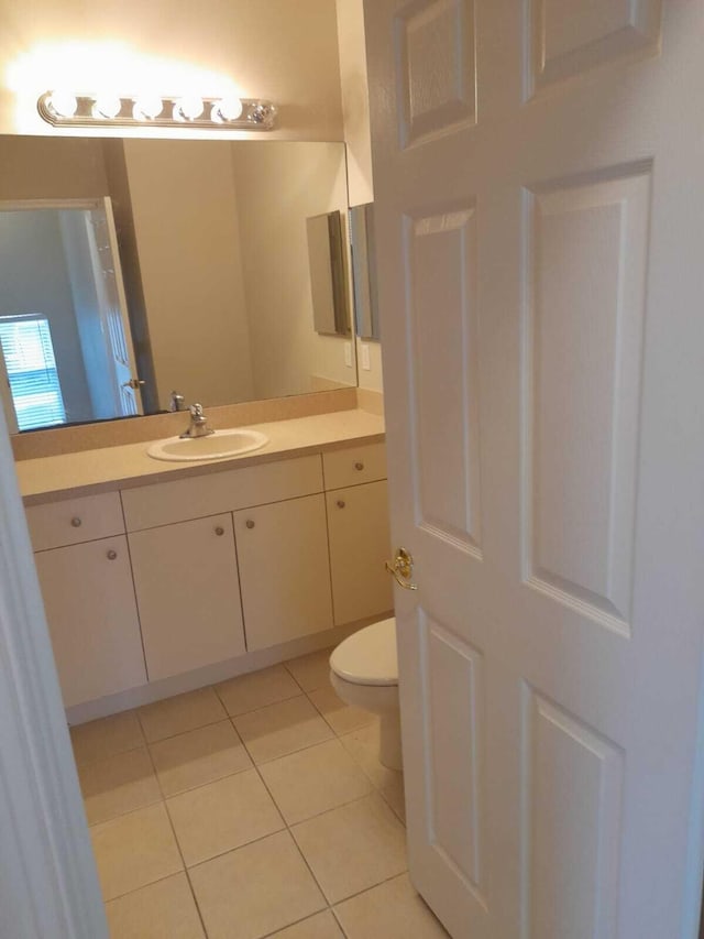 bathroom featuring vanity, tile patterned flooring, and toilet