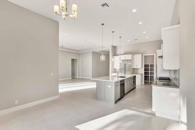 kitchen featuring white cabinetry, sink, an island with sink, and pendant lighting