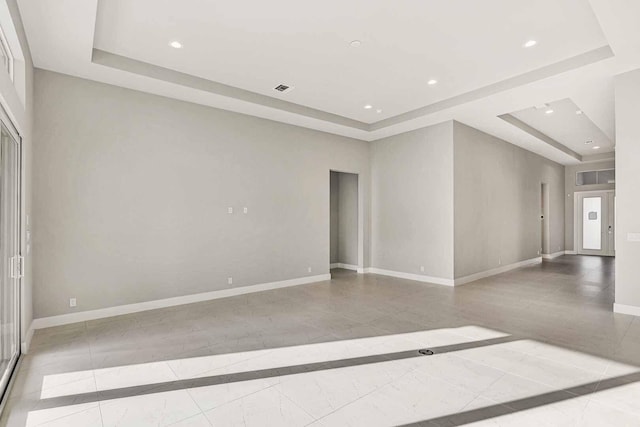 unfurnished room with a tray ceiling