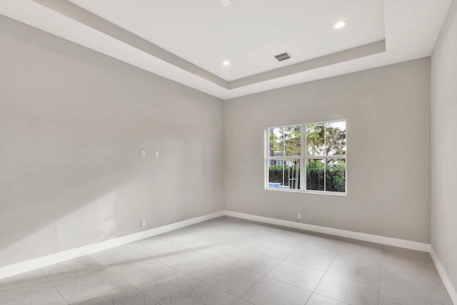 spare room with a tray ceiling