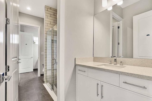 bathroom with a shower with door and vanity