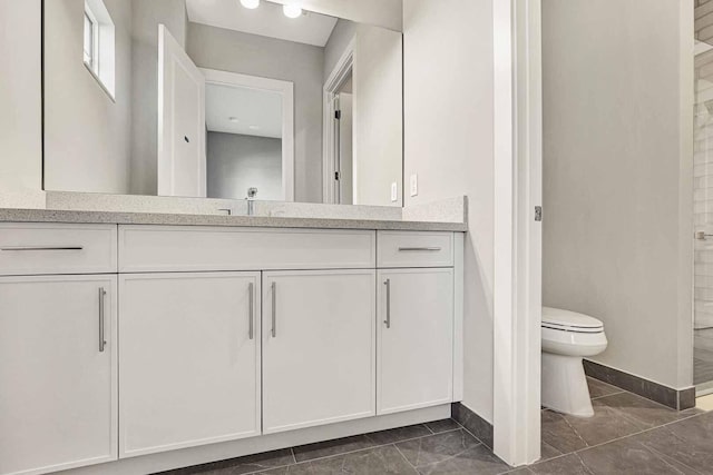 bathroom with vanity, tile patterned flooring, and toilet