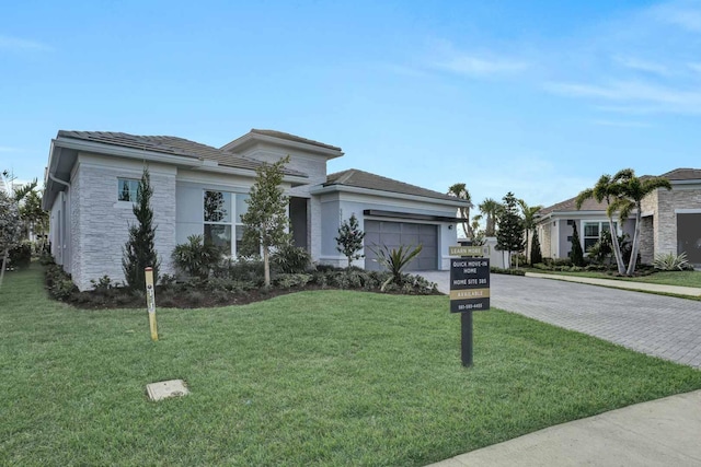 view of front of property featuring a garage and a front lawn