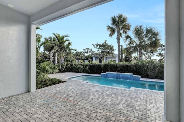 view of swimming pool with pool water feature and a patio area