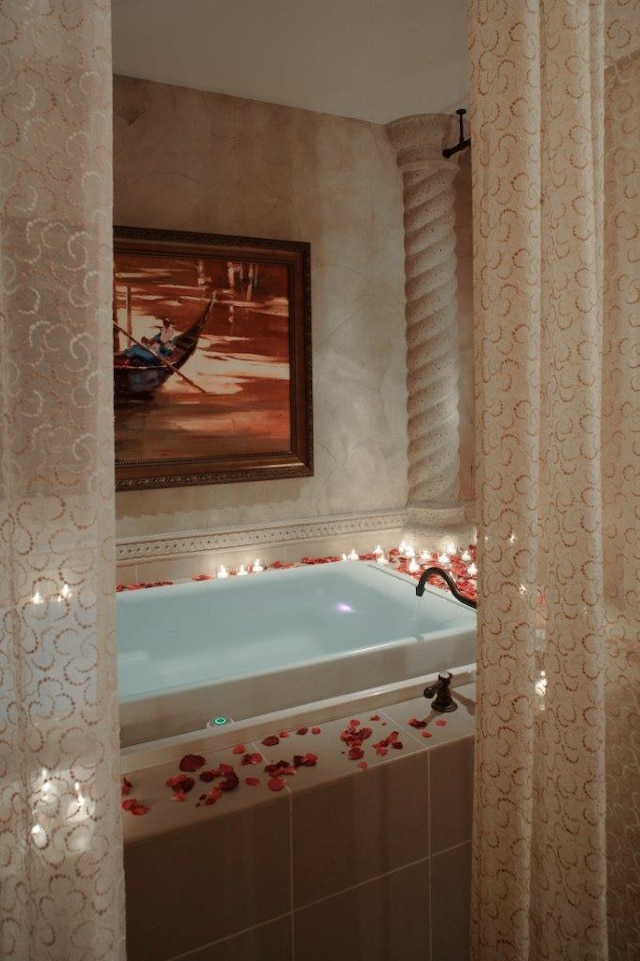 bathroom with a bathing tub and tile walls