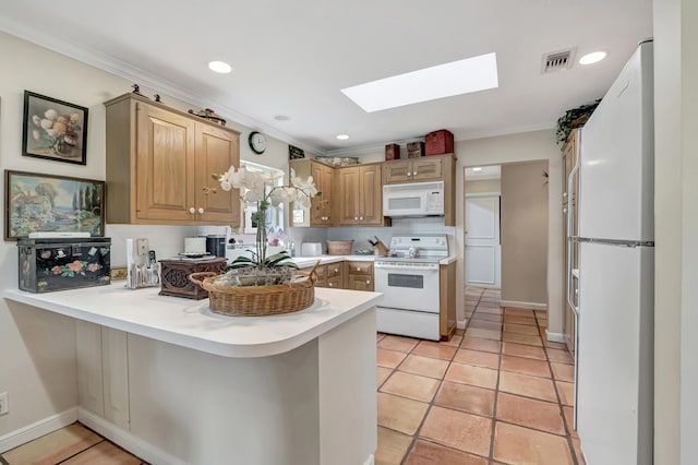 kitchen featuring a skylight, light tile patterned flooring, kitchen peninsula, and white appliances