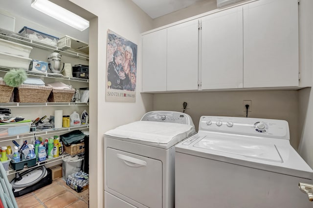 laundry area with cabinets, light tile patterned flooring, and washer and clothes dryer