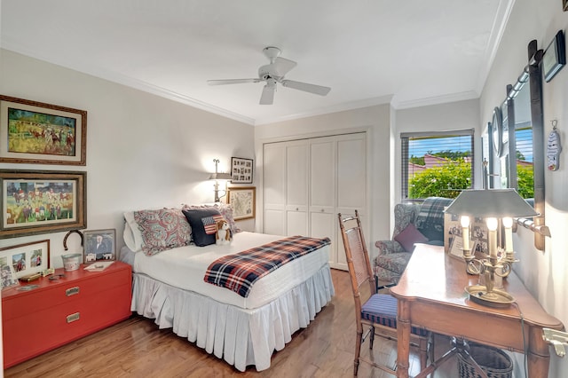 bedroom with ceiling fan, crown molding, a closet, and hardwood / wood-style floors