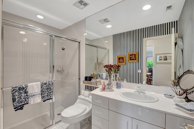 bathroom featuring a shower with shower door, vanity, tile patterned flooring, and toilet