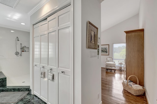 corridor featuring ornamental molding, dark hardwood / wood-style flooring, and vaulted ceiling